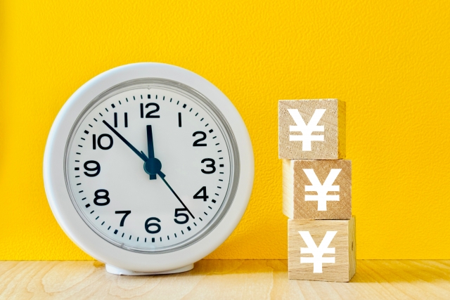 時計と円マークの積み木が並ぶ画像